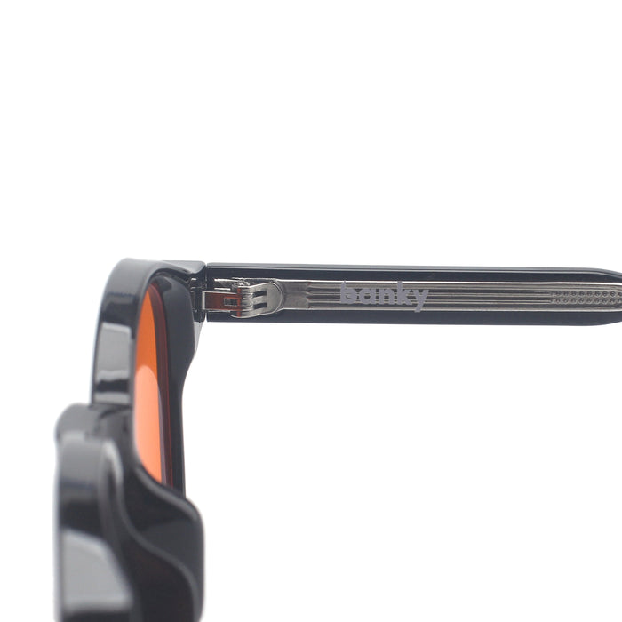 Banky-logo op de metalen inleg bij het scharnier van de zwarte bril